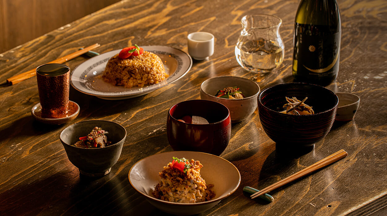 Seasonal dishes and sake on a wooden table at 一献うるうる